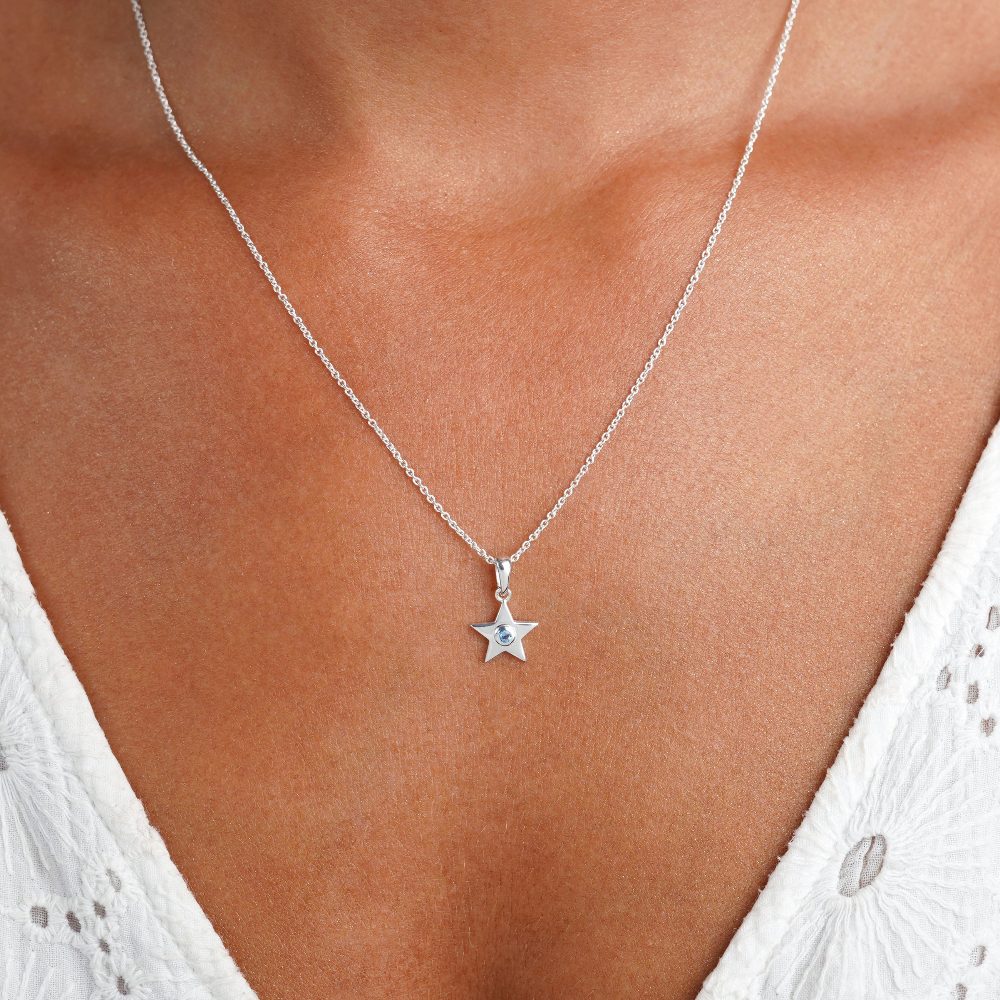 Collar de plata con una estrella y un pequeño cristal de Topacio Azul. Collar diciembre en plata con la piedra de nacimiento y una estrella plateada.