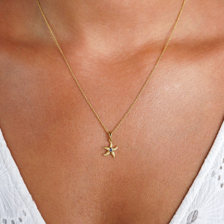 Collar de estrella de mar en oro y con la piedra de nacimiento de septiembre Iolita. Collar de oro con estrella de mar y piedra preciosa Iolita.