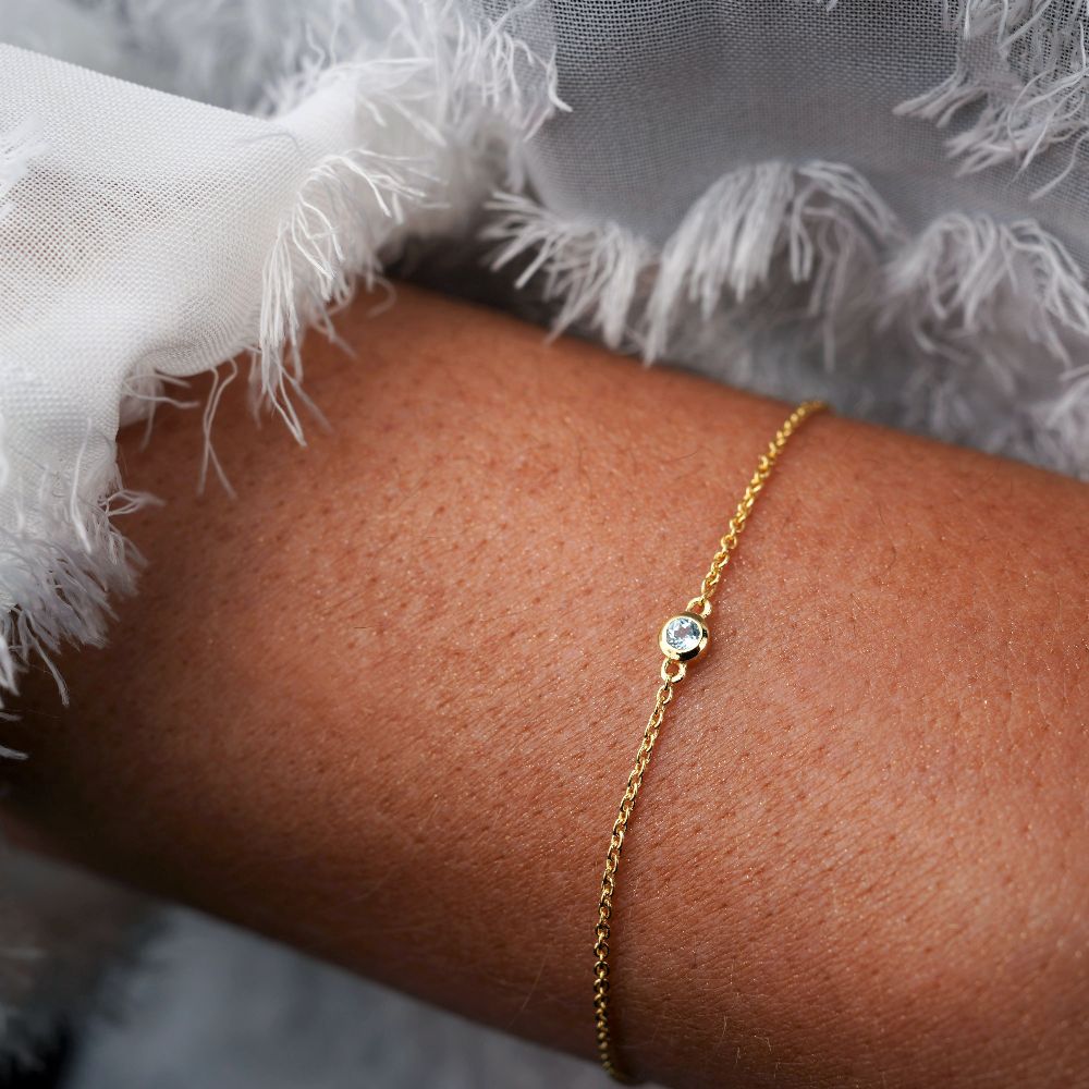 Pulsera de oro con topacio azul cristal que es la piedra de nacimiento de diciembre. Pulsera con Piedra Azul Topacio, que significa comunicación.