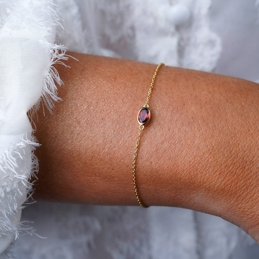 Pulsera de oro con cristal rojo Granate. Pulsera con piedra natal de enero Granate en oro.